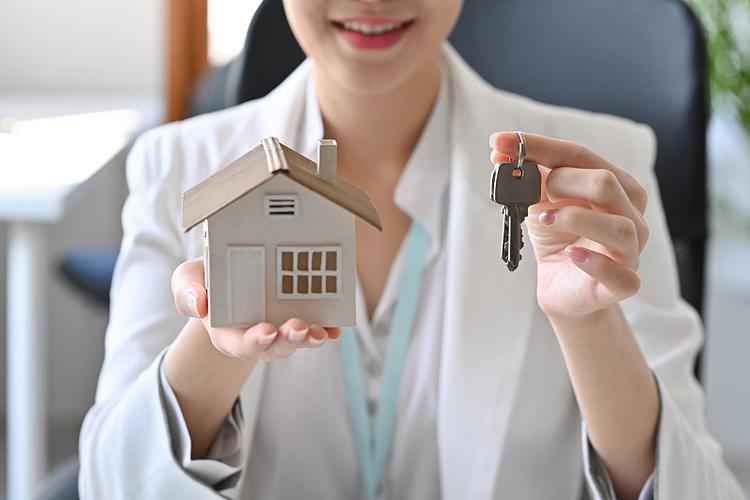 房地产中介持有房屋模型和钥匙.抵押与房地产投资概念.图片